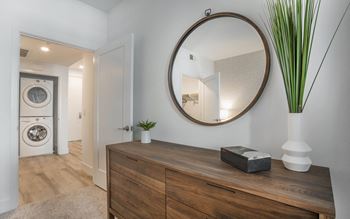 a living room with a mirror and a washer and dryer